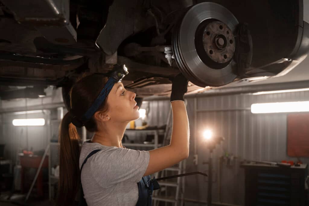 Woman is repairing the car exhaust.